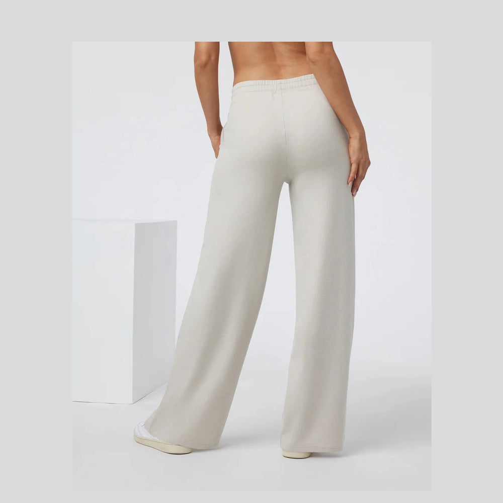 Person wearing beige Vuori Halo Essential Wideleg – Women's wide-leg pants on a white background