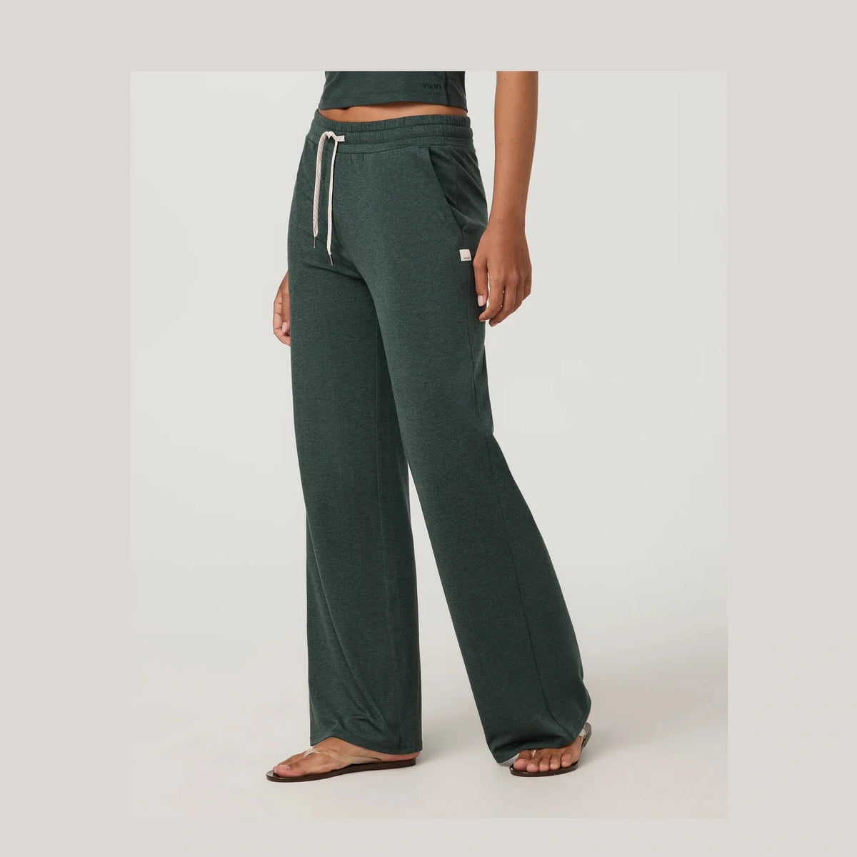 A person wearing dark green wide-leg Halo Essential Wideleg Short – Women's with a white drawstring, shown from the waist down against a light gray studio background.