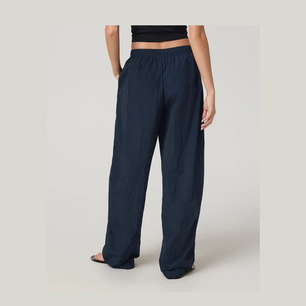 Navy blue wide-leg Retrograde Track Pant--Women's pants worn by a person on a light gray background