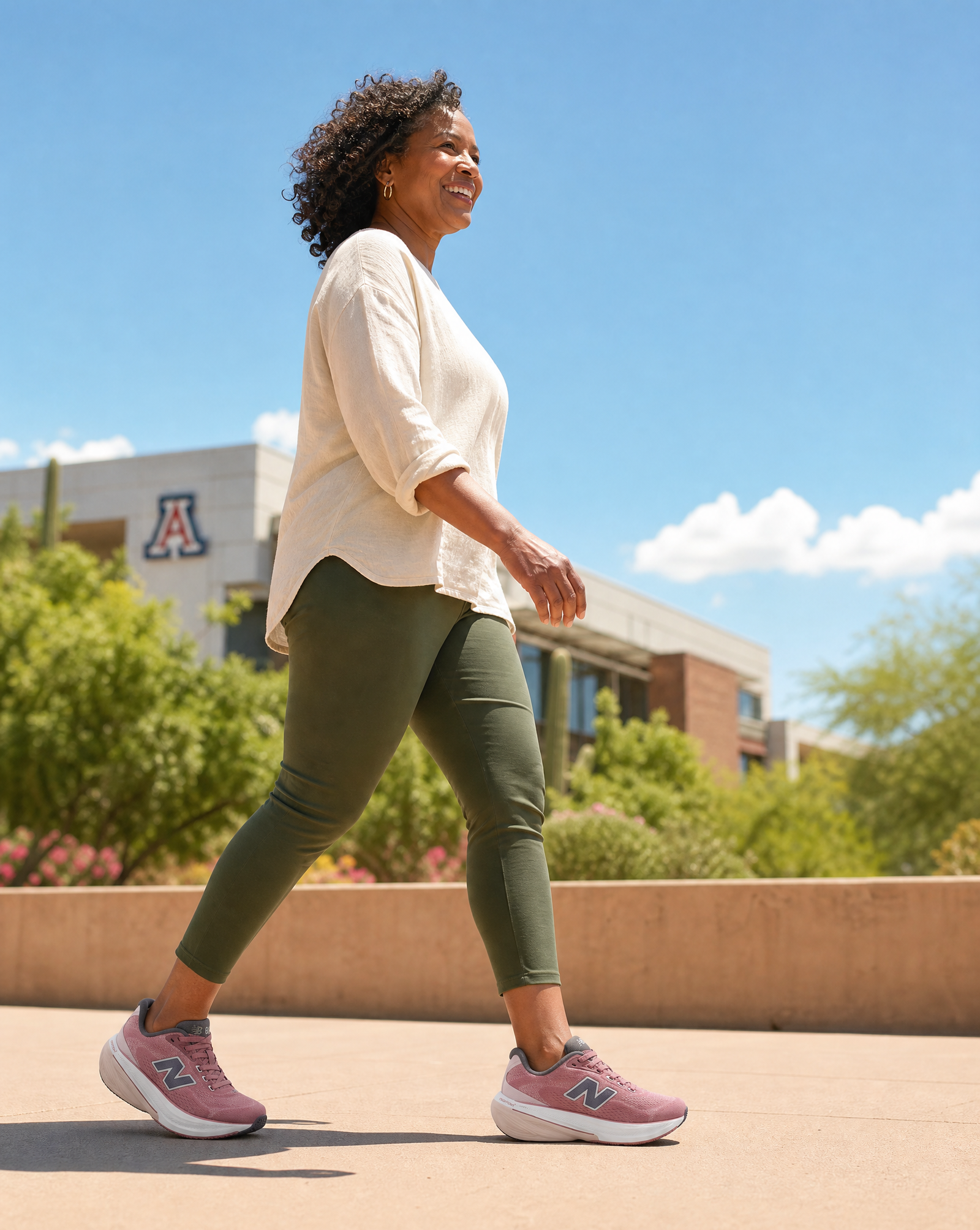 Woman walking outdoors with a building and trees in the background