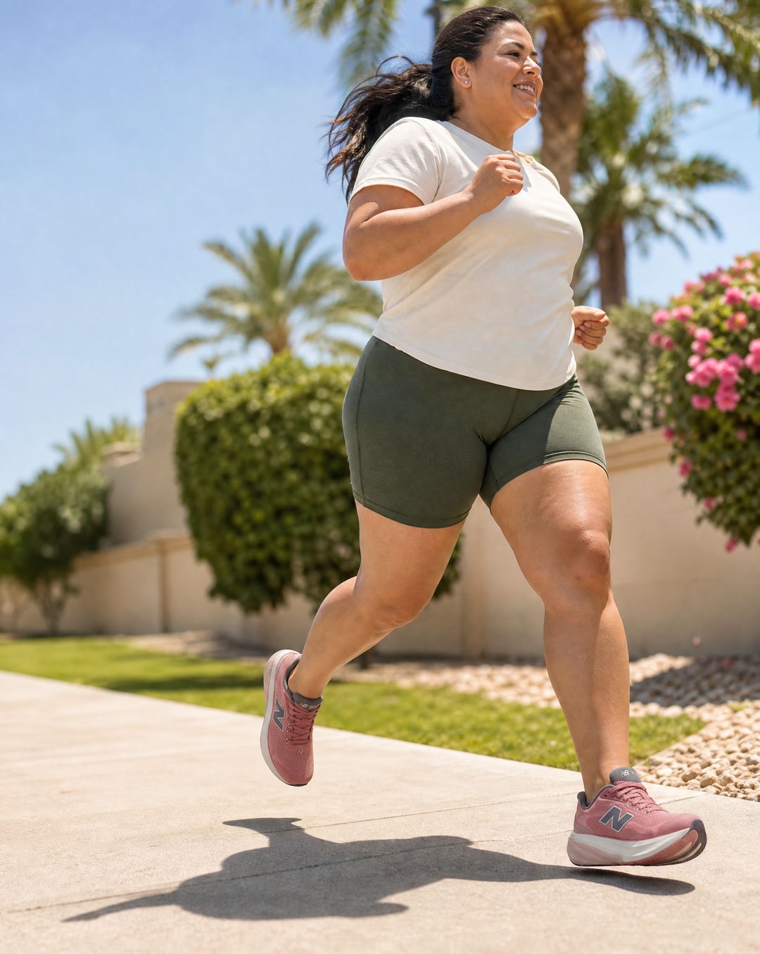 Woman running outdoors with palm trees and flowers in the background