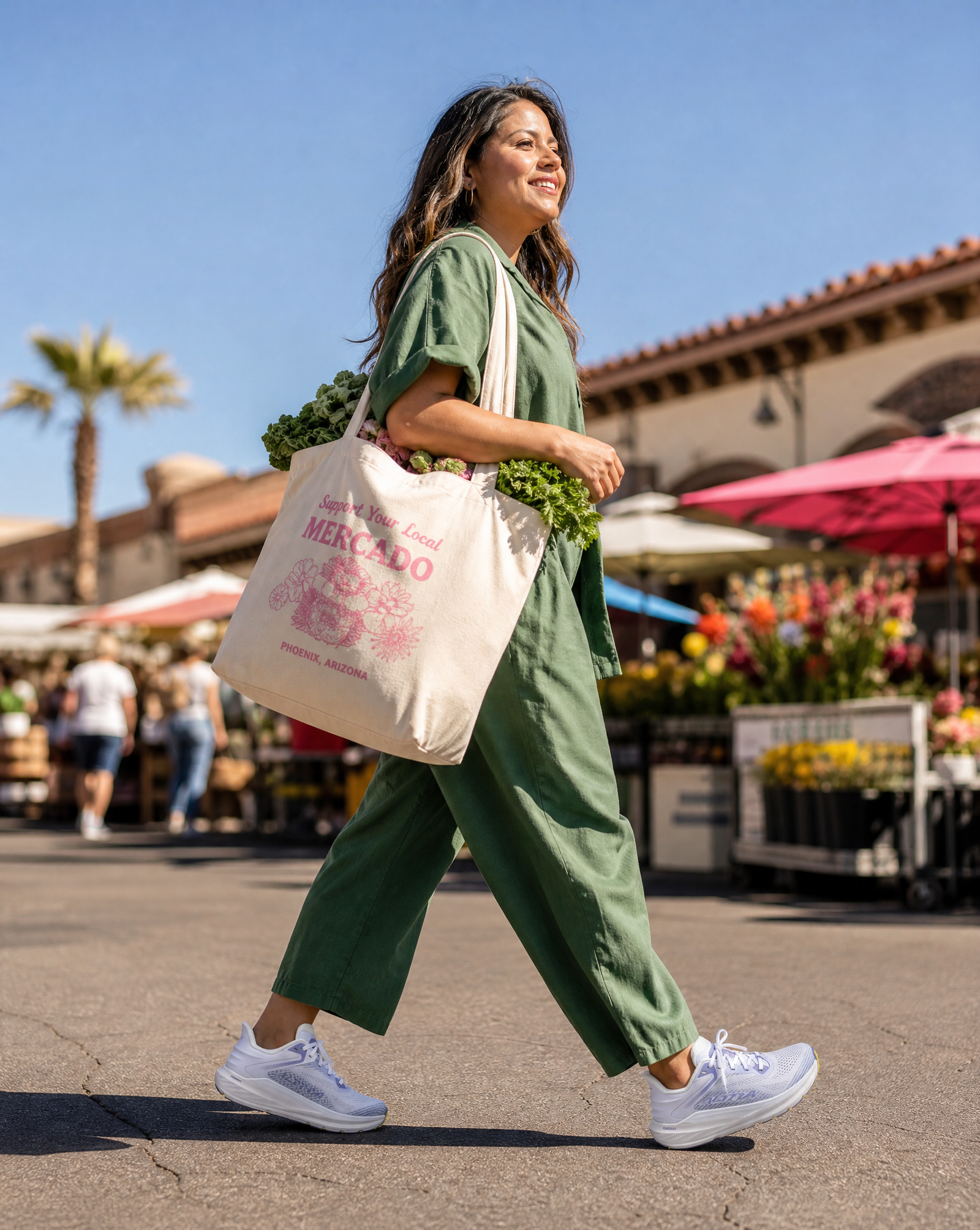 Woman walking outdoors in Altra Torin 8 running shoes with a reusable shopping bag at a farmers market.