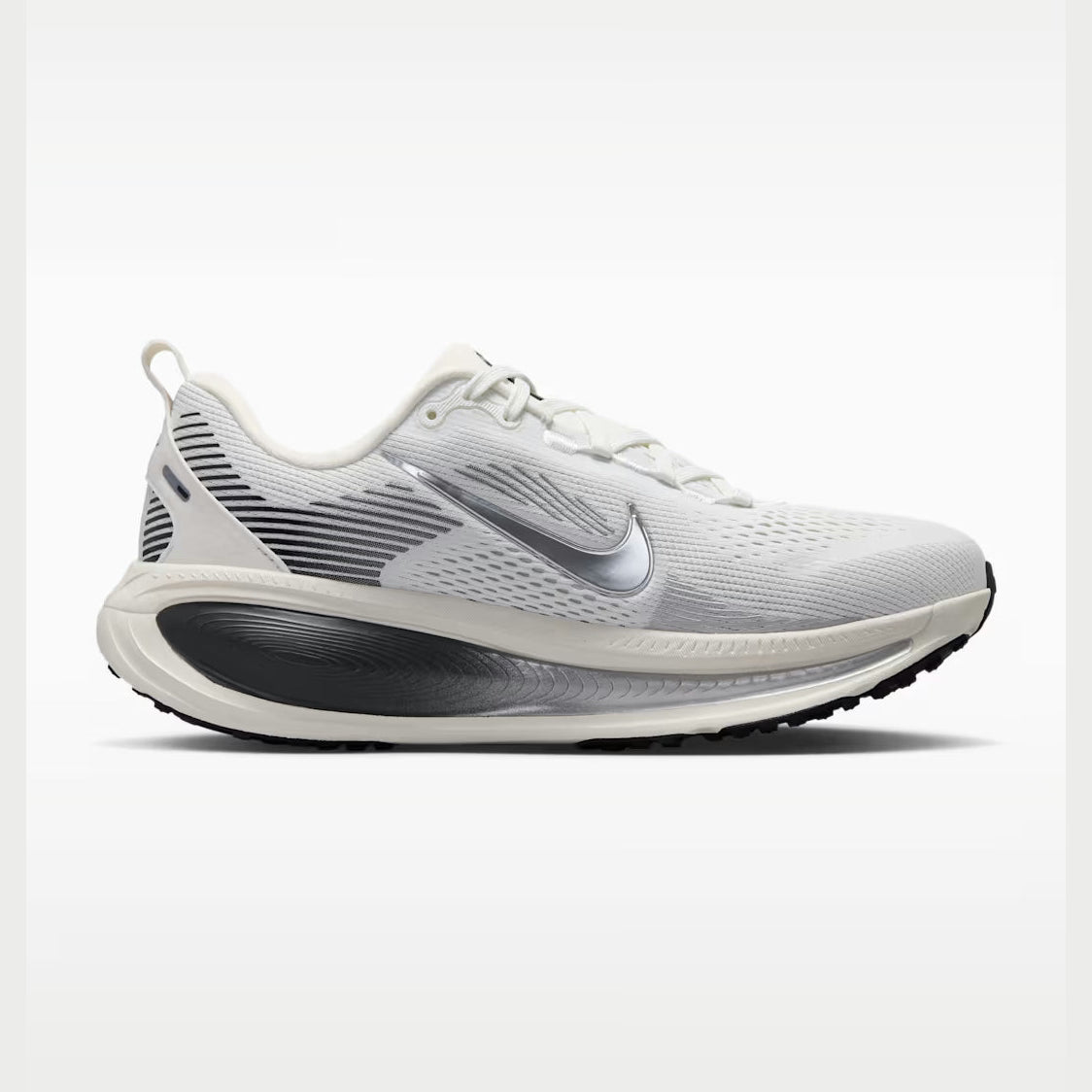 A Vomero 18 --Women's running shoe in white and light gray with a metallic silver Swoosh logo, shown from a side profile against a clean white background.