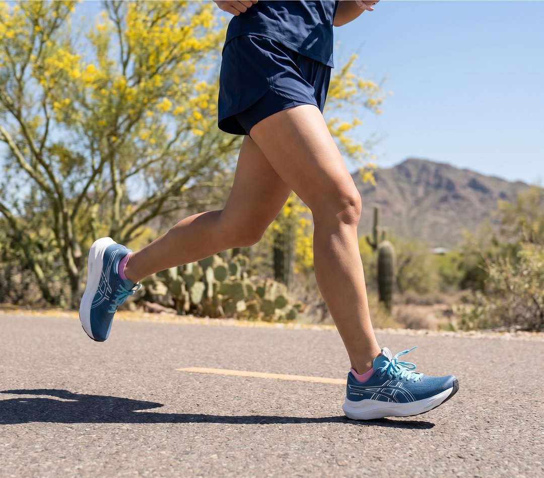 Person running on a road with desert landscape in the background
