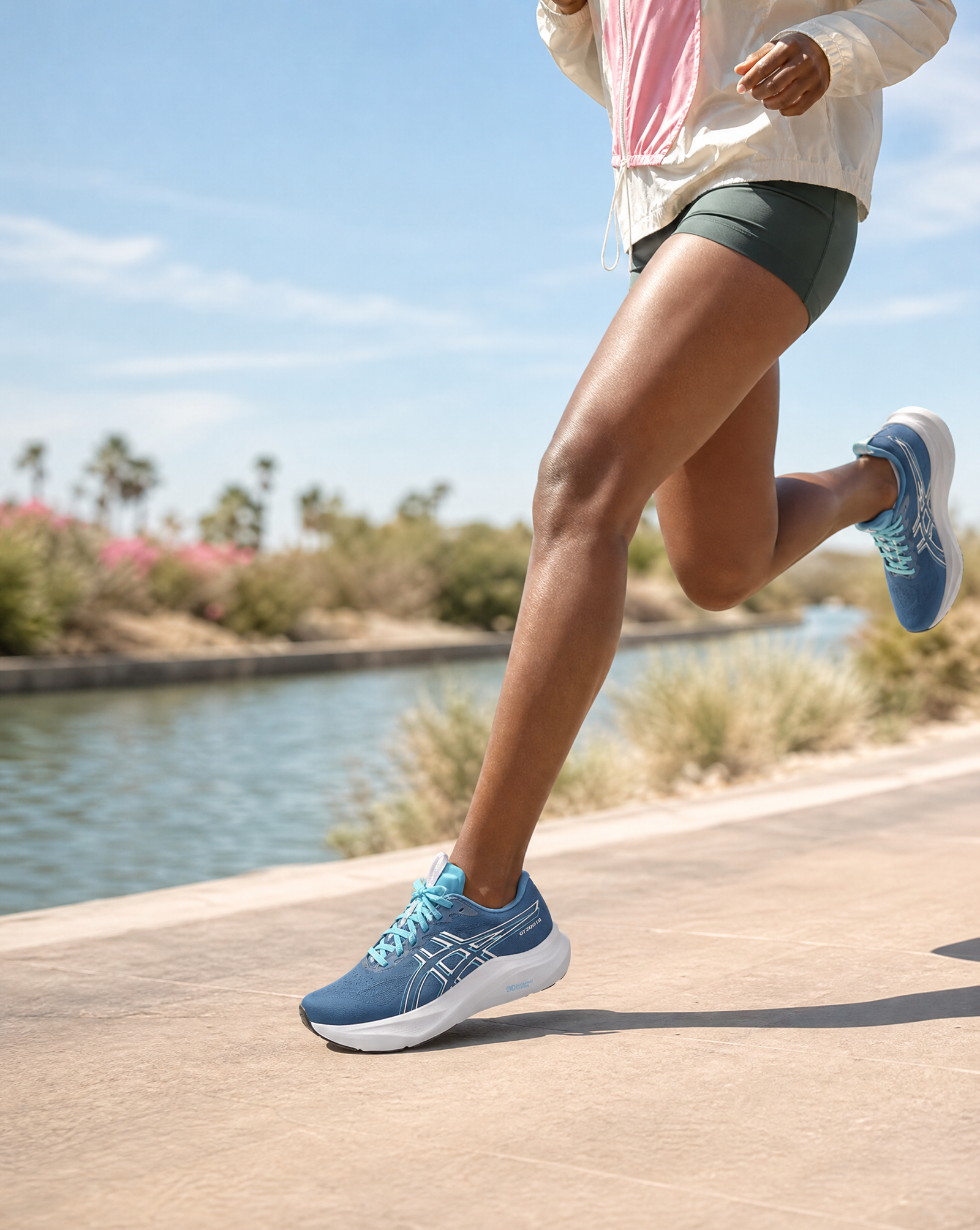 Person running on a path by a body of water with blue shoes