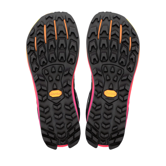 A pair of trail running shoes shown from the bottom, displaying their black Vibram soles with bright pink and orange accents.