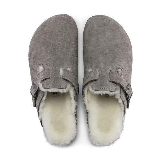 Pair of gray Birkenstock Boston Shearling--Suede Stone Coin with white fur lining on a white background