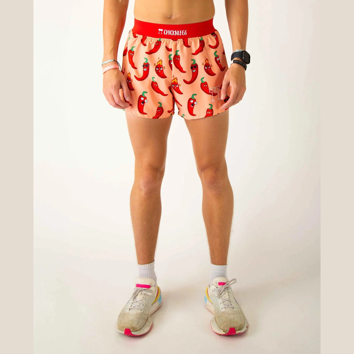 Person wearing a red waistband and chili pepper patterned Chicknlegs 4" Half Split Shorts – Men's on a white background