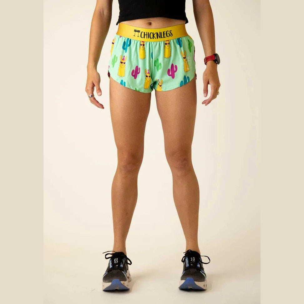 Person wearing colorful Chicknlegs 1.5" Split Shorts – Women's with a cactus pattern on a plain background