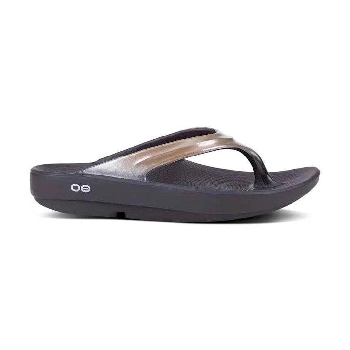 Latte OOfos OOlala sandal with a metallic toe post on a white background