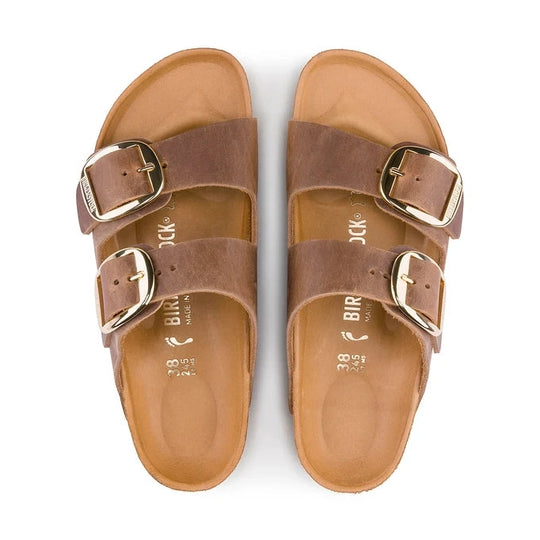 Pair of brown BIRKENSTOCK Arizona Big Buckle sandals with gold buckles on a white background
