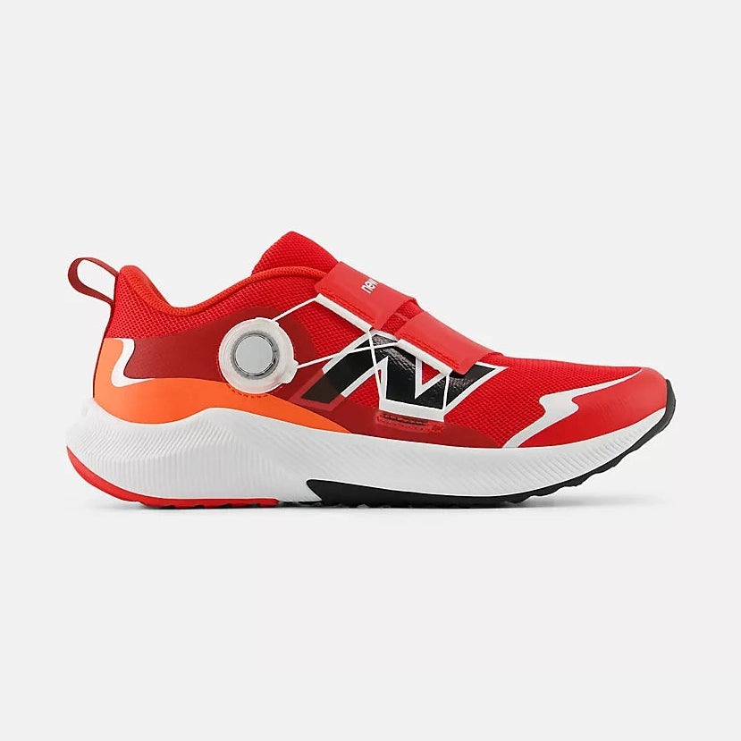 A red and white New Balance Reveal V4 BOA – Kids' running shoe with a circular dial closure system, black and white graphic accents, and a bright orange midsole section, shown from a side profile on a light gray background.