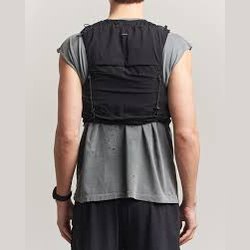 A man shown from the back wearing a blackJustice Cordura 5L Hydration Vest over a gray t-shirt and dark pants, against a plain light gray background.