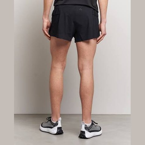 Rear view of a person wearing black Space-O Shorts--Men's and gray and white running shoes against a plain light gray studio background.