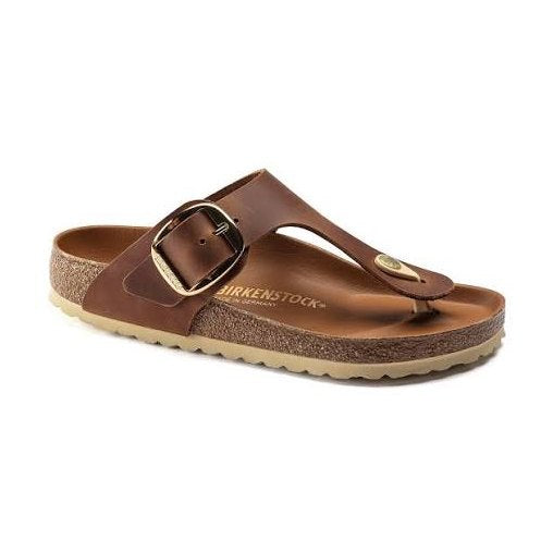 A brown leather BIRKENSTOCK Gizeh Big Buckle sandal with a wide adjustable strap and a gold-tone buckle, shown from a three-quarters angle on a white background.