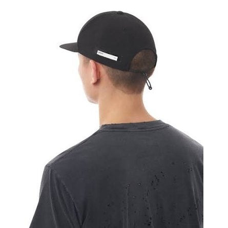 Person wearing a black Flitesilk 5 Panel Pinch Cap and black t-shirt on a white background