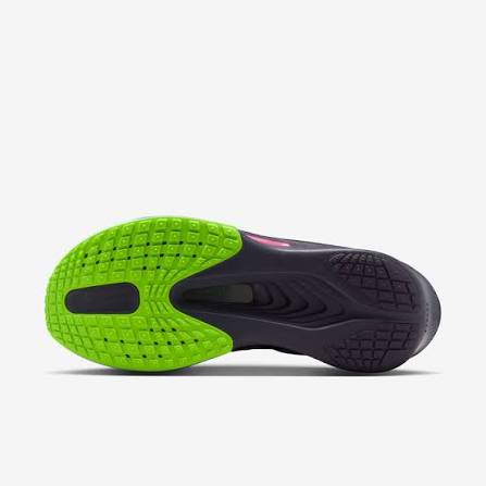 Close-up of a shoe sole with green and black tread pattern on a white background