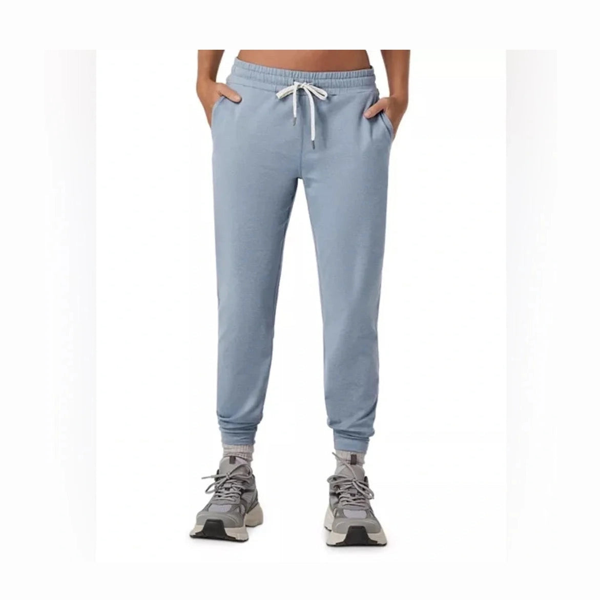Light blue Vuori Performance Jogger – Women's jogger sweatpants with a white drawstring, modeled on a person from the waist down wearing gray sneakers against a white background.
