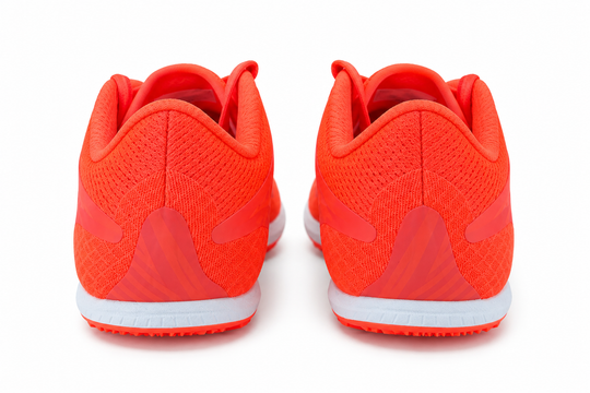 A pair of bright orange New Balance Xc7 V4 – Men&