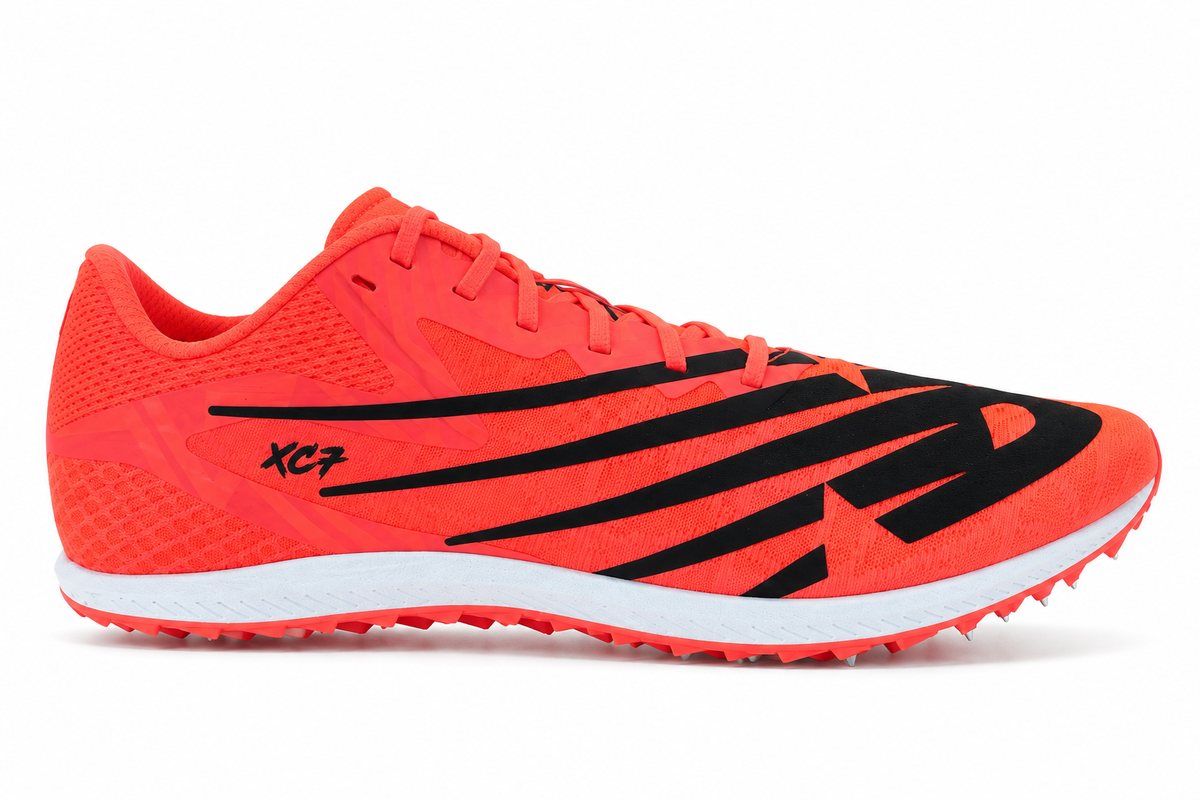A bright orange-red New Balance Xc7 V4 – Men's athletic track shoe with black graphic stripes and a white midsole, shown in profile against a white background.