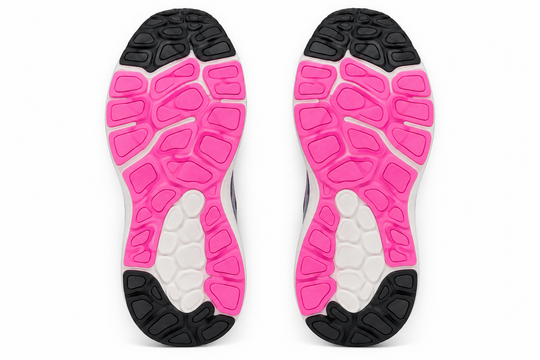 The outsoles of a pair of athletic shoes, showing a design with bright pink, white, and black textured sections, photographed against a solid white background.