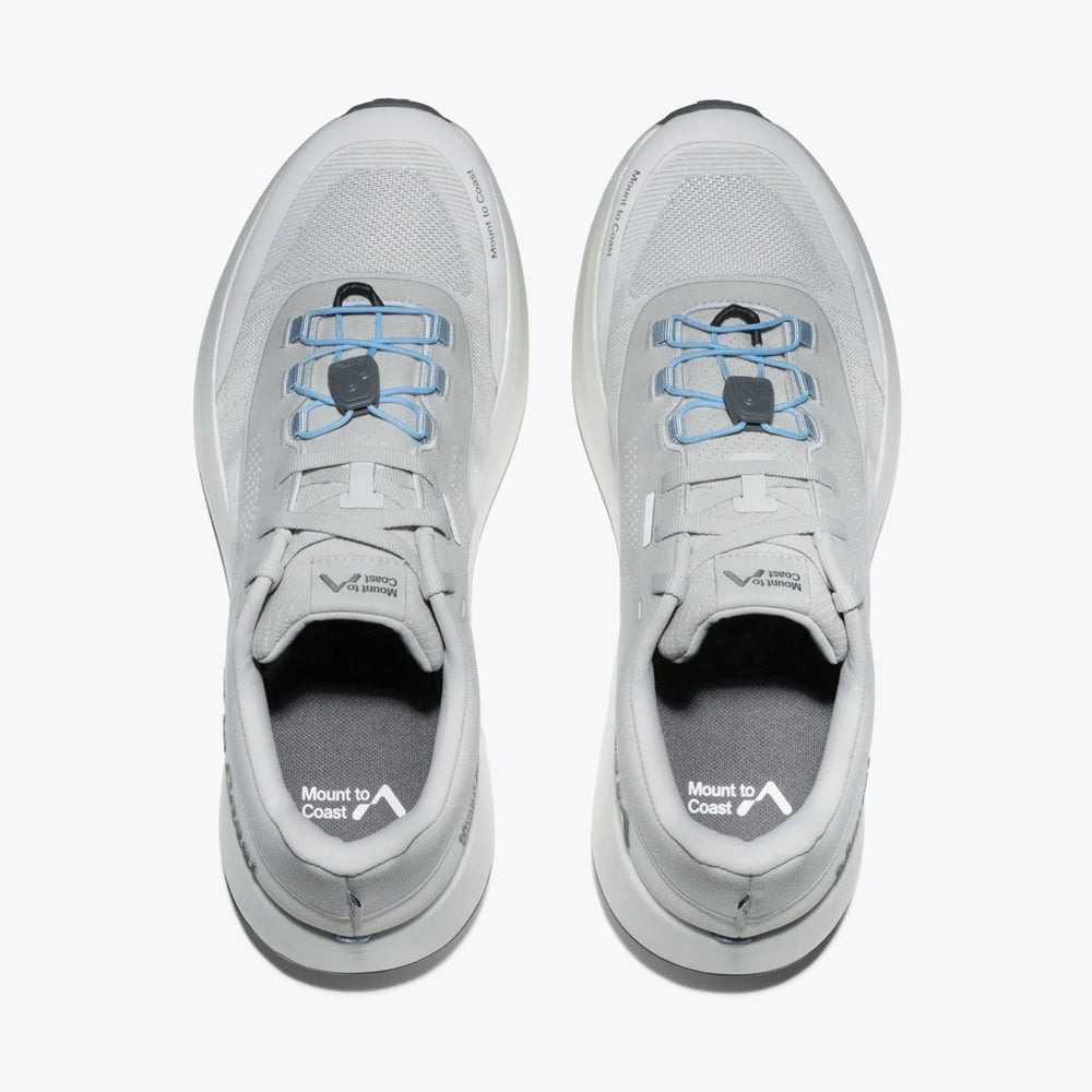A pair of light gray and white H1 -- Women's trail running shoes shown from a top-down view, featuring light blue lace accents and a white midsole, with the Mount to Coast brand logo visible on the insoles.