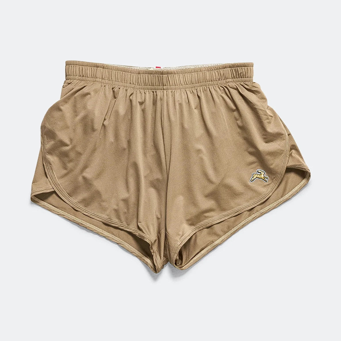 A pair of beige Twilight Split Shorts – Women's athletic shorts with an elastic waistband and a small embroidered logo on the lower left leg, displayed flat against a light gray background.