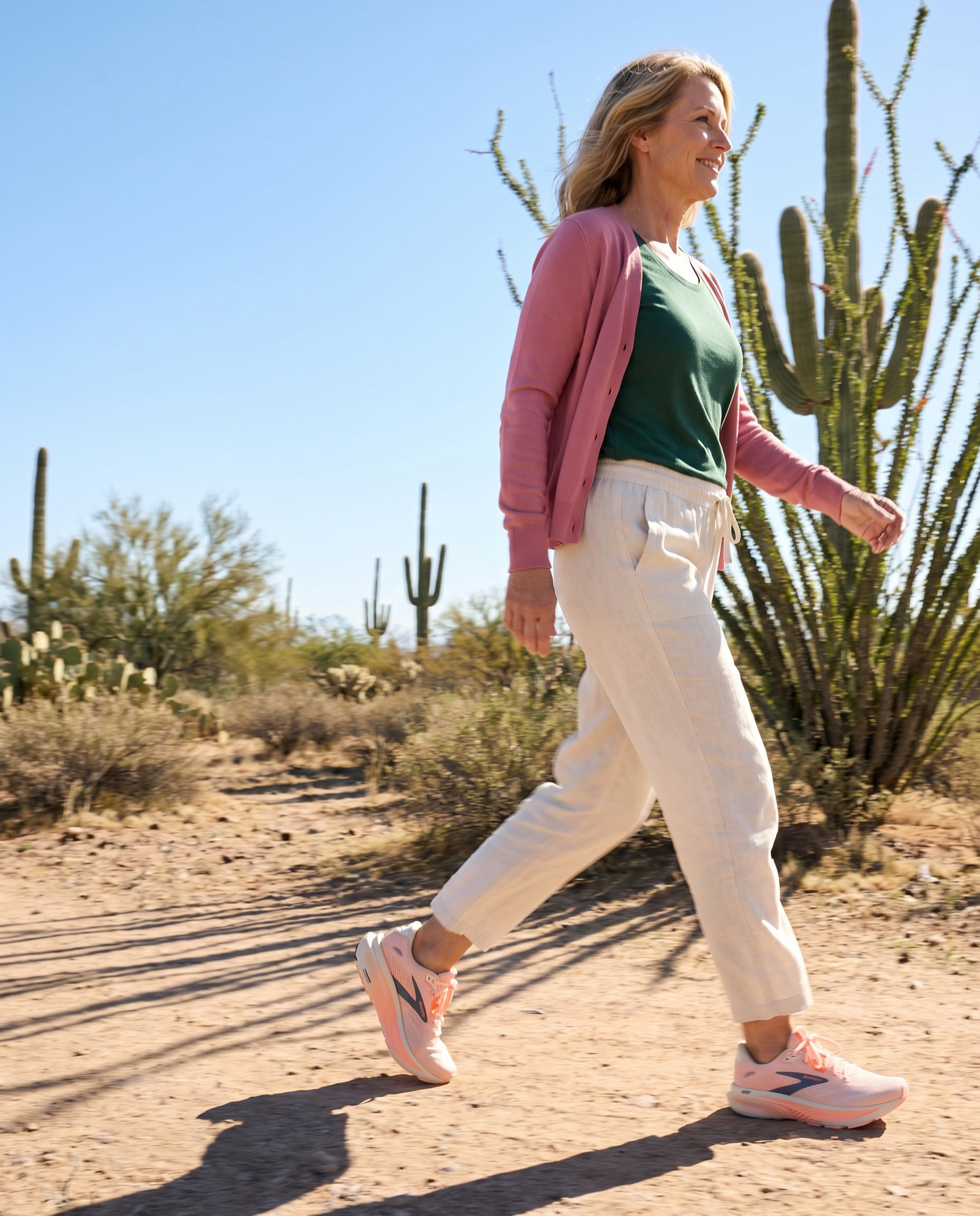 Woman walking in a desert landscape with cacti in the Brooks Ghost 18